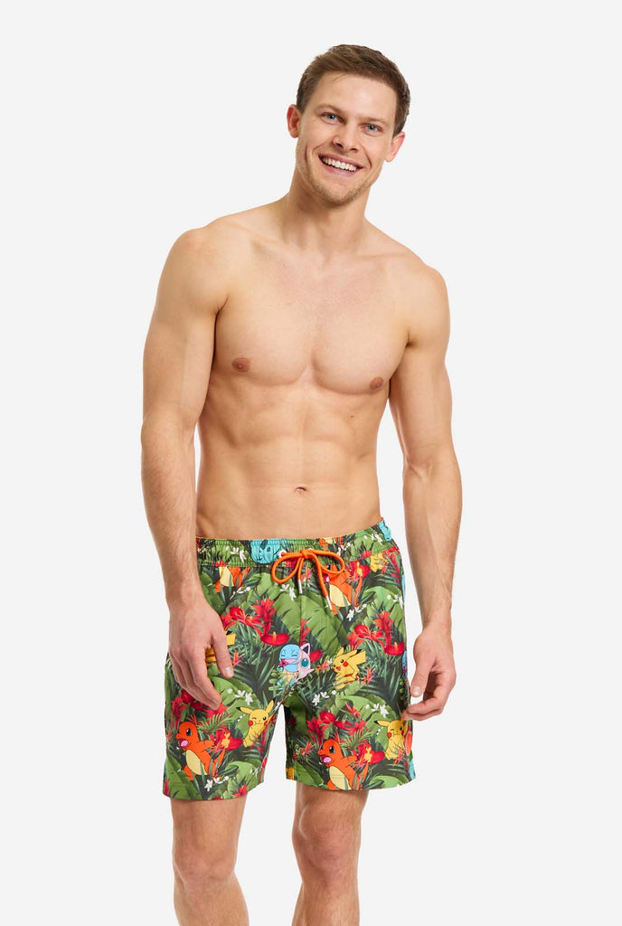 Man wearing swim trunks with Pokemon forest print