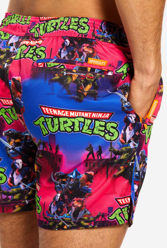 Man wearing TMNT Dude swim trunks for men, close up