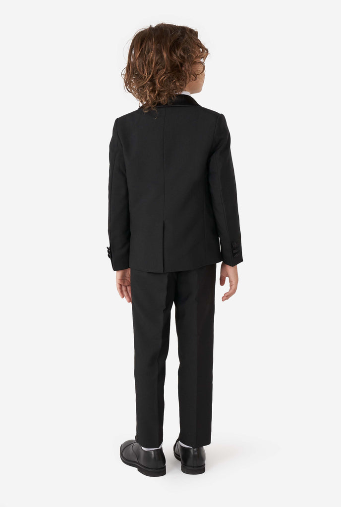 Kid wearing black tuxedo, view from the back