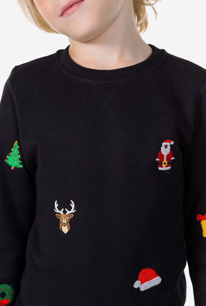 Kid wearing black Christmas sweater with Christmas icons, close up