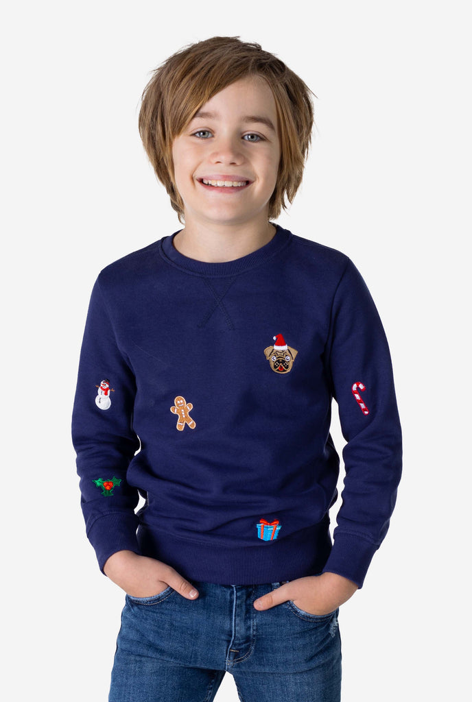 Kid wearing blue Christmas sweater with Christmas icons