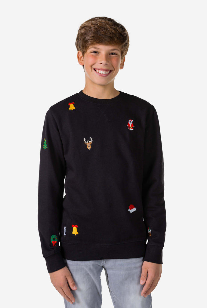 Teen wearing black Christmas sweater with Christmas icons