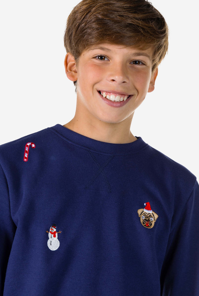 Kid wearing blue Christmas sweater with Christmas icons, close up