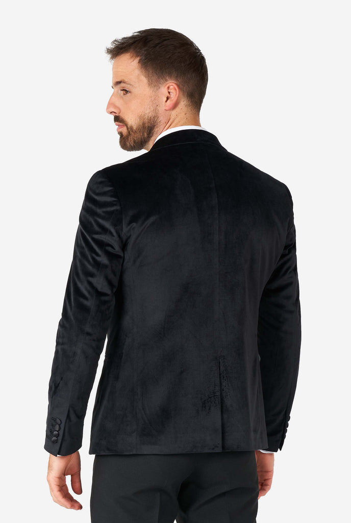 Man wearing black velvet dinner jacket blazer, view from the back