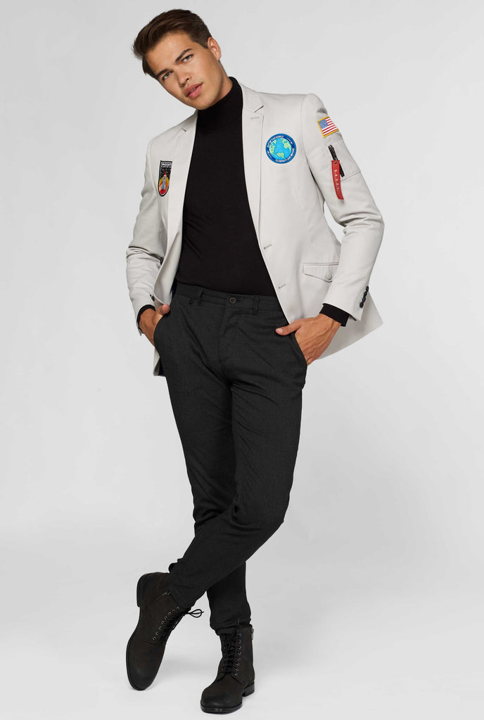 Light grey blazer with astronaut themed patches worn by man