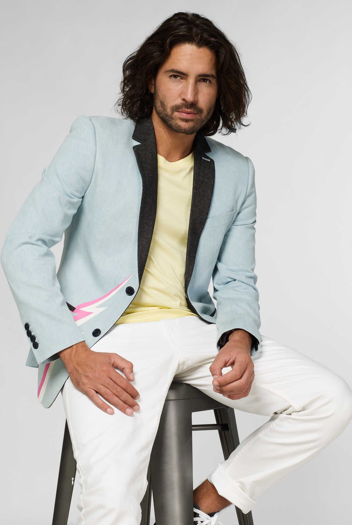 Blue casual blazer with white and pink lightning bolt worn by man sitting on a stool