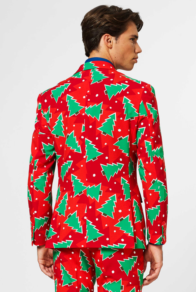 Red Christmas suit with pine tree print worn by man shown from behind