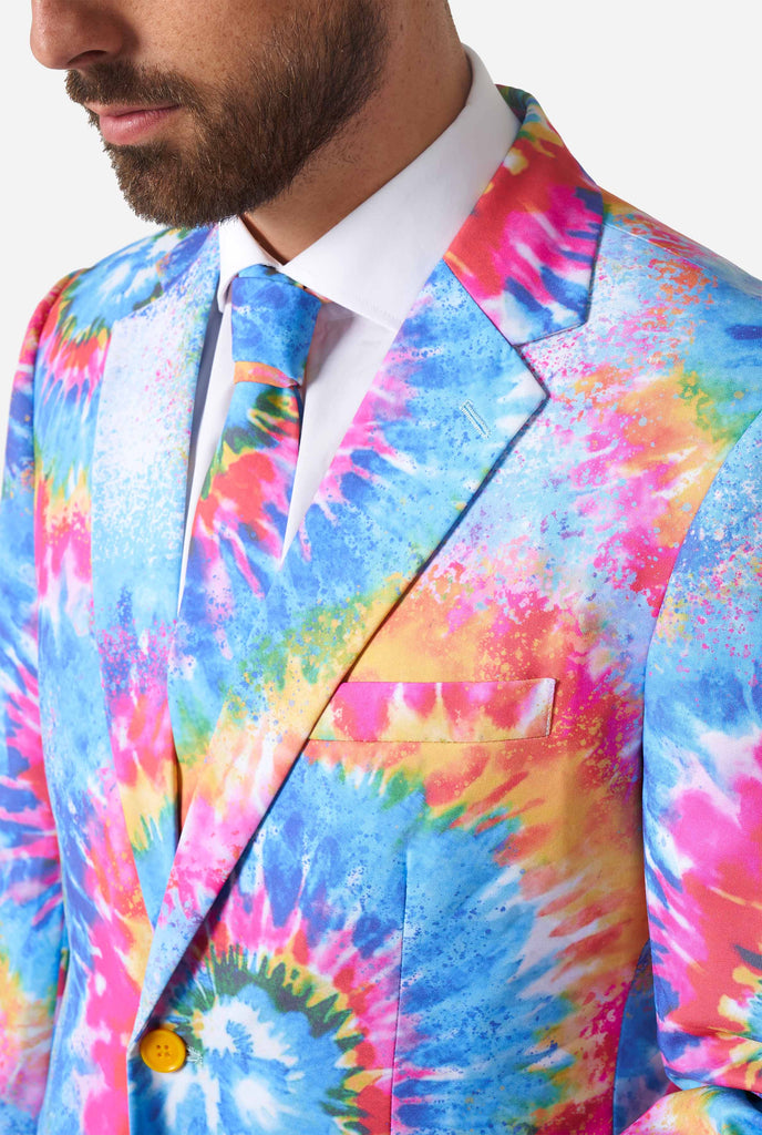 Man wearing pride men's suit with colorful tie dye rainbow print, close up