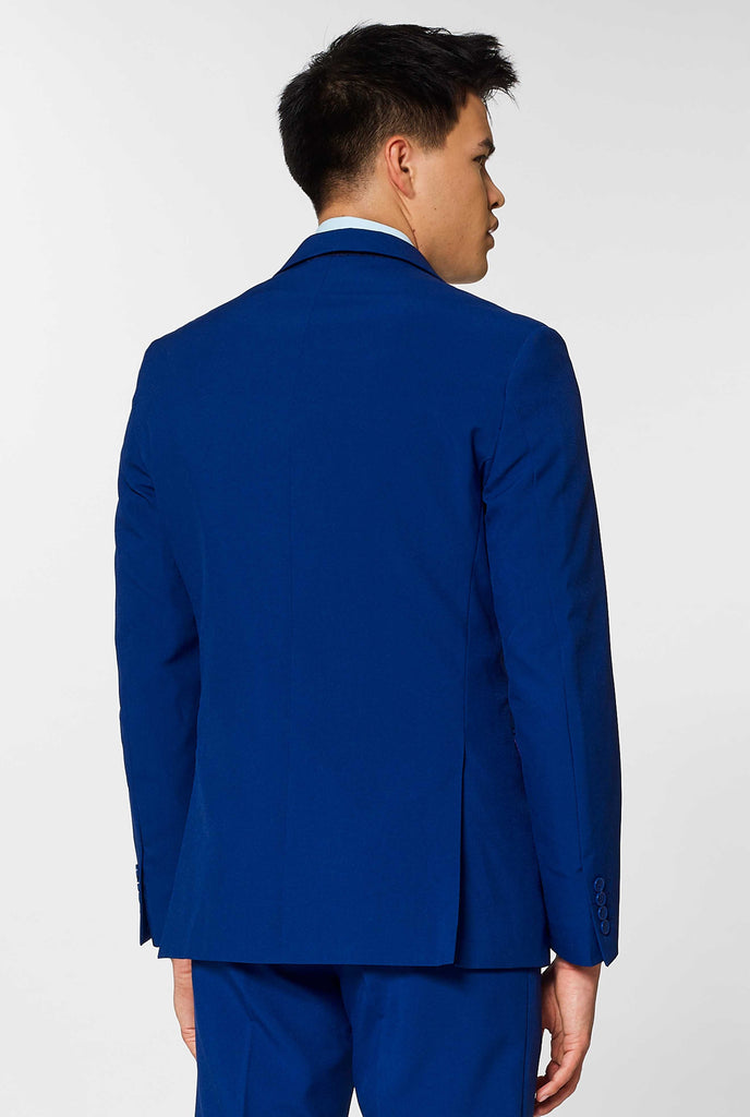 Navy blue solid colored men's suit worn by man, view from the back