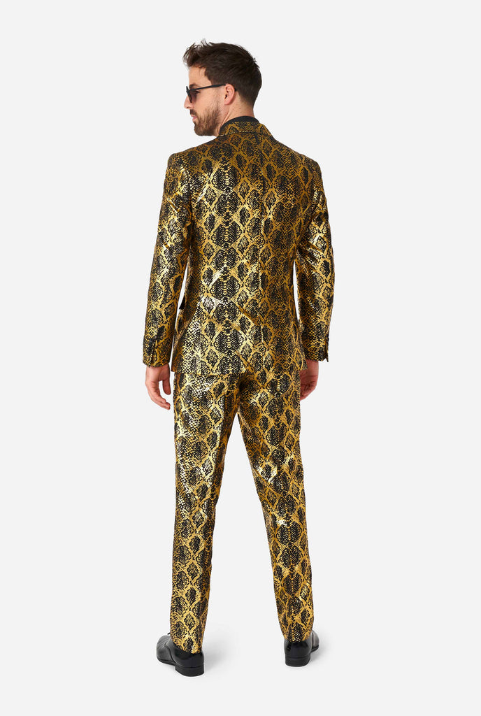 Man wearing suit with, gold and black, snakeskin print view from the back