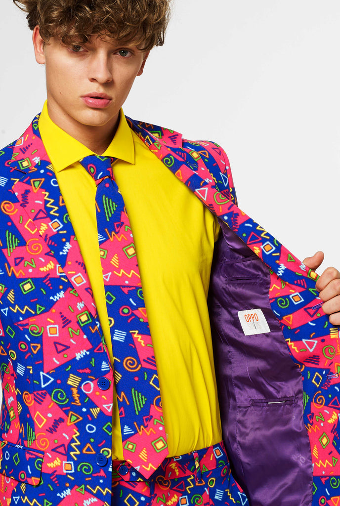 Funky pink and blue suit with abstract icons worn by man showing inside of jacket