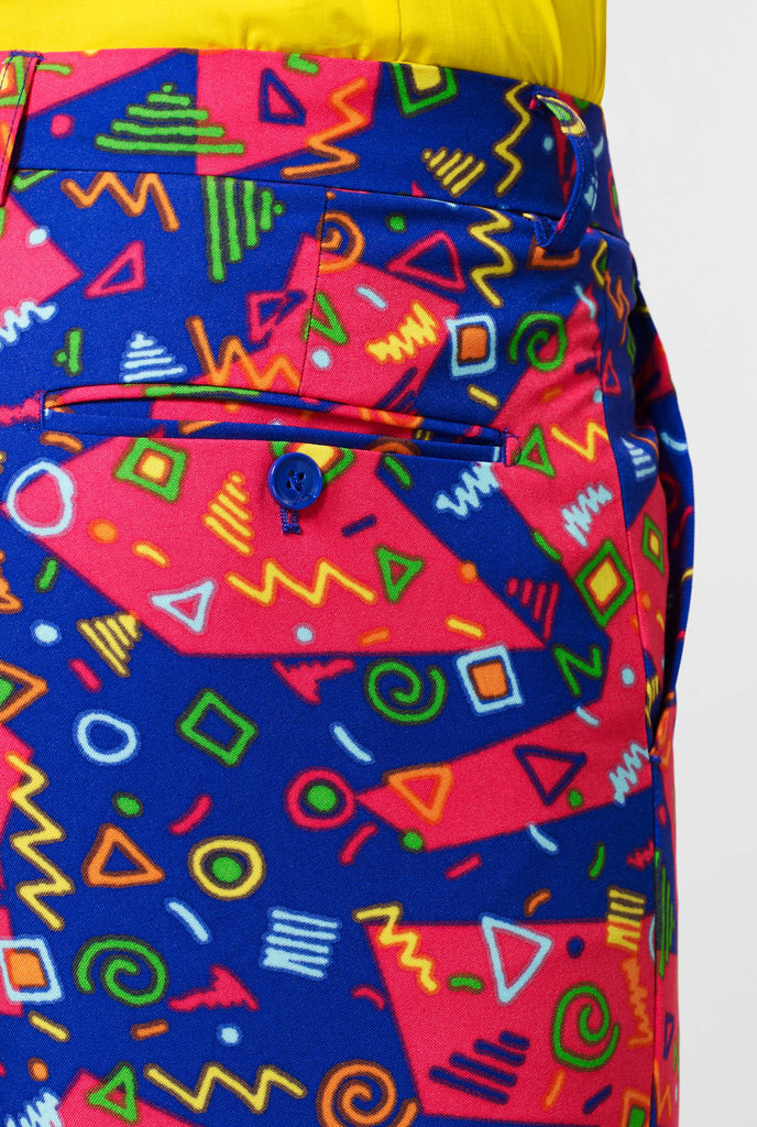 Funky pink and blue suit pants with abstract icons up close