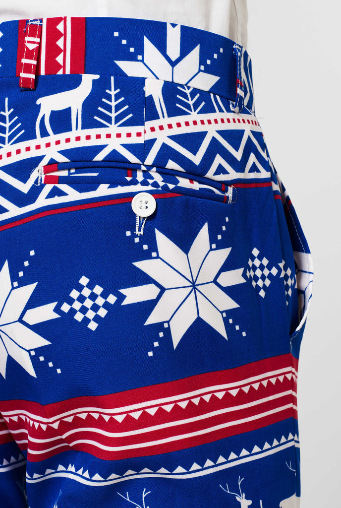 Man wearing blue Christmas suit with Nordic themed print, pants close up