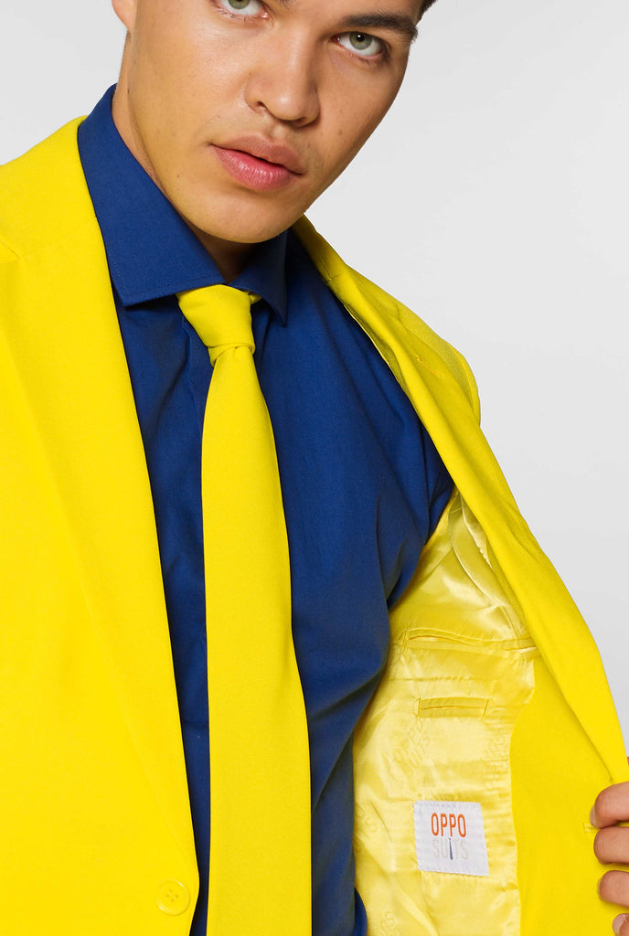 Man wearing yellow men's suit and dark blue dress shirt, close up