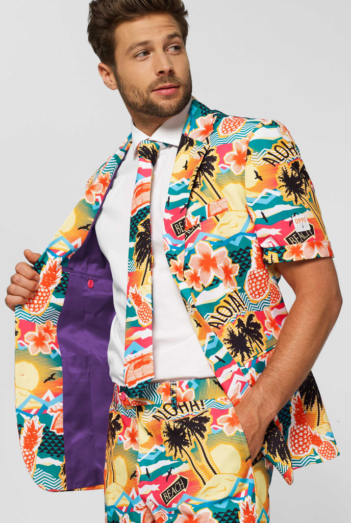 Man wearing colorful Hawaiian print summer suit, consisting of short, jacket and tie