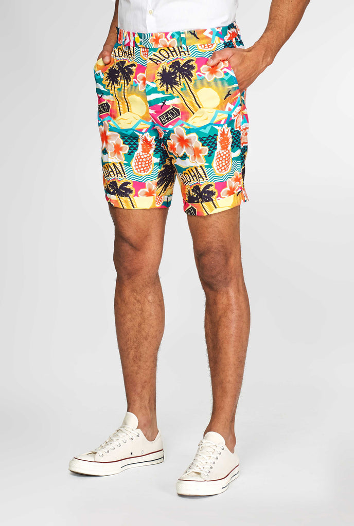 Man wearing colorful Hawaiian print summer suit, consisting of short, jacket and tie, close up of pants