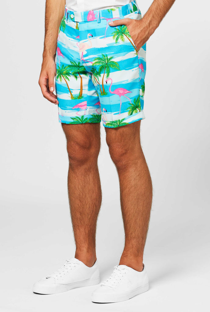 Man wearing summer suit with tropical flamingo print, close up of pants