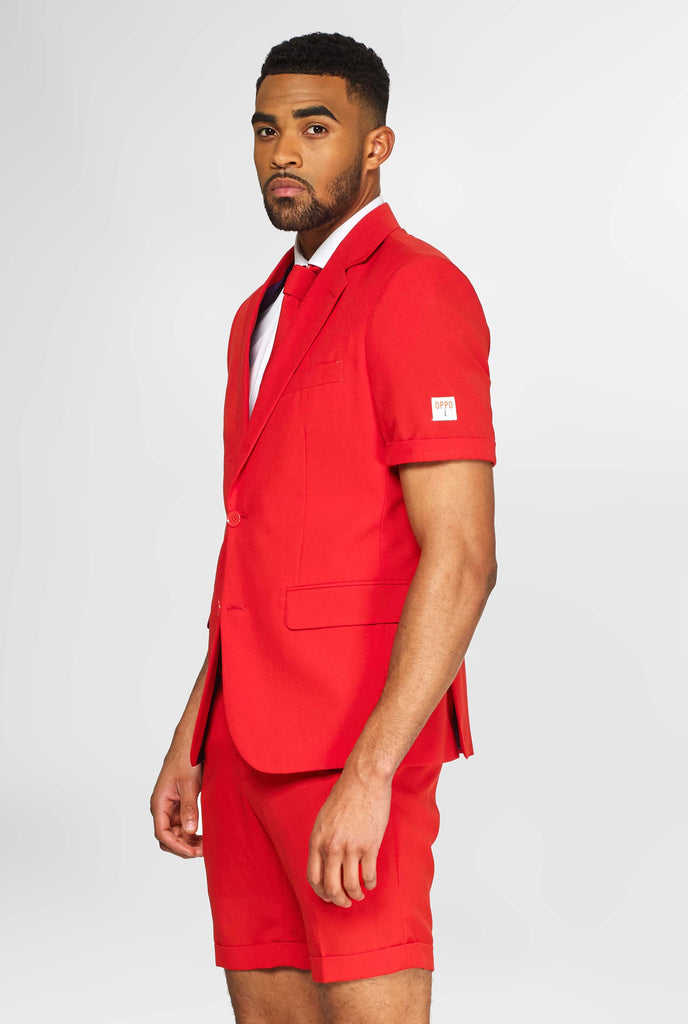 Man wearing red summer suit, consisting of shorts, jacket and tie