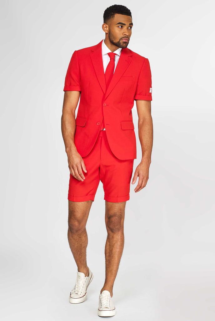 Man wearing red summer suit, consisting of shorts, jacket and tie