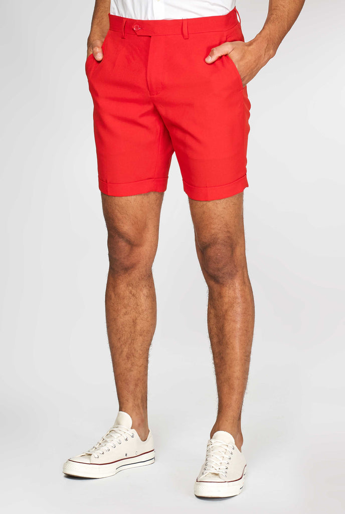 Man wearing red summer suit, consisting of shorts, jacket and tie, close up of pants