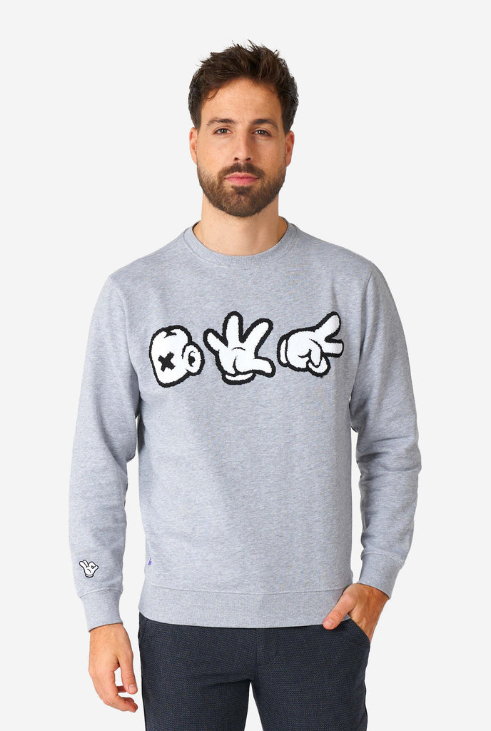 Man wearing grey sweater with chenille rock, paper, scissors embroidery