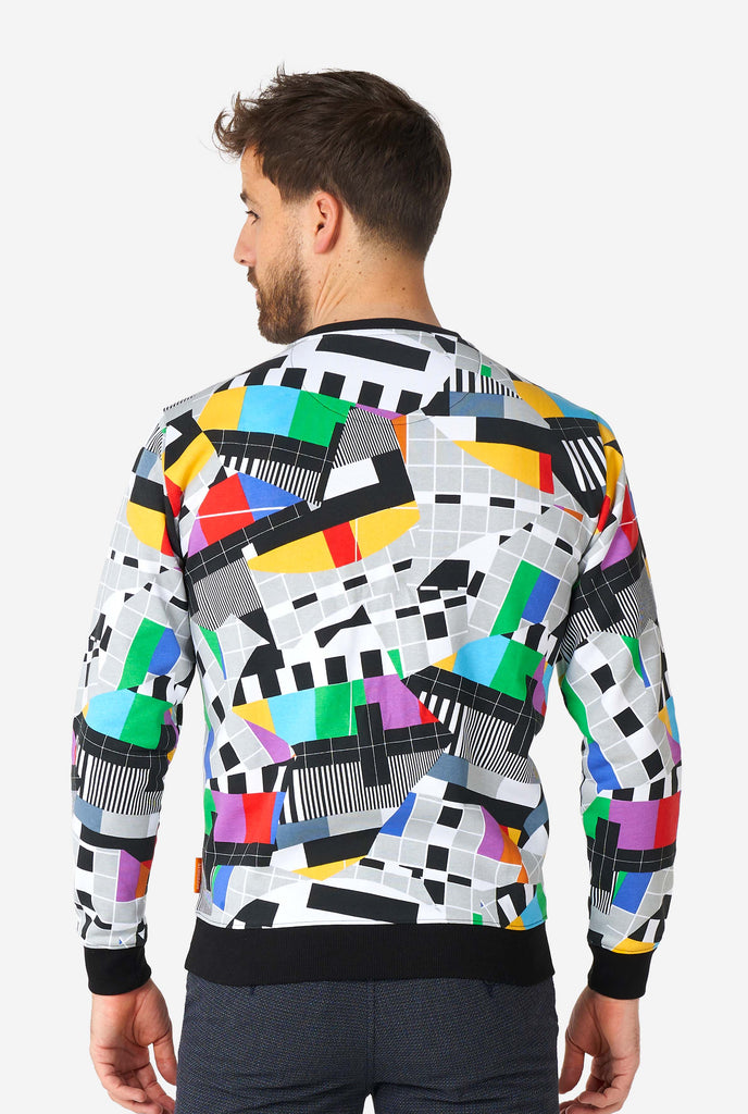 Man wearing retro TV-testscreen multi-color sweater, view from the back