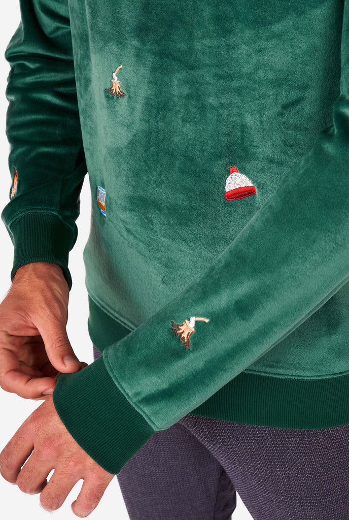 Man wearing velvet green Christmas sweater with Christmas icons, close up