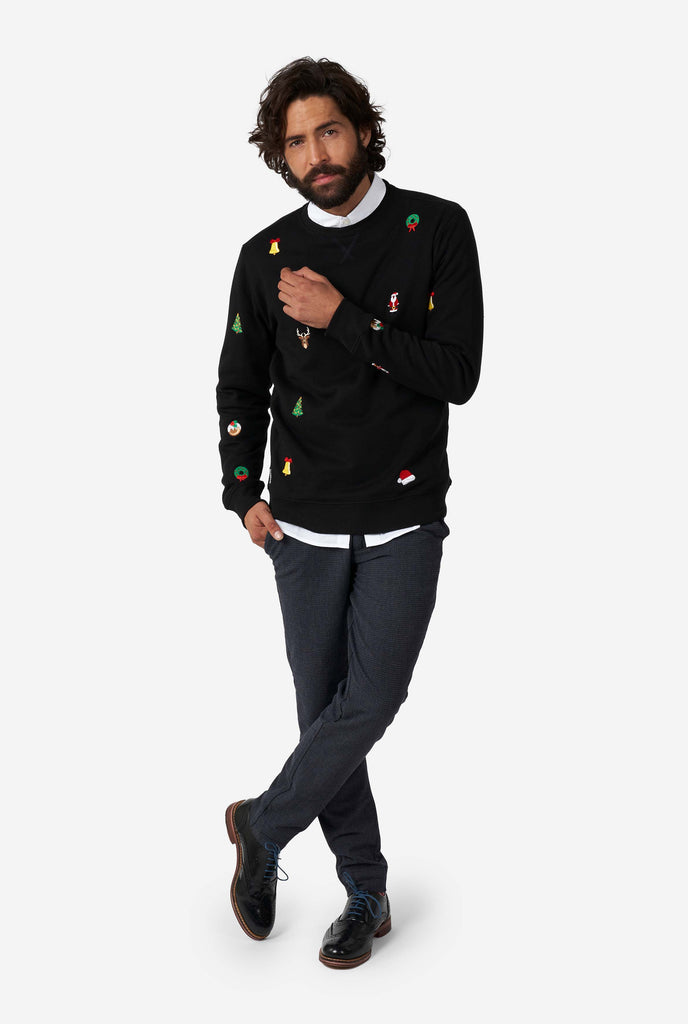 Man wearing black Christmas sweater with Christmas icons