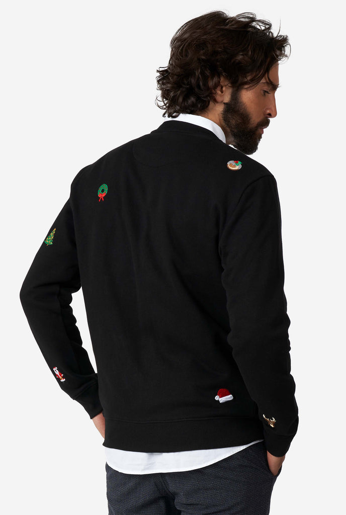 Man wearing black Christmas sweater with Christmas icons, view from the back