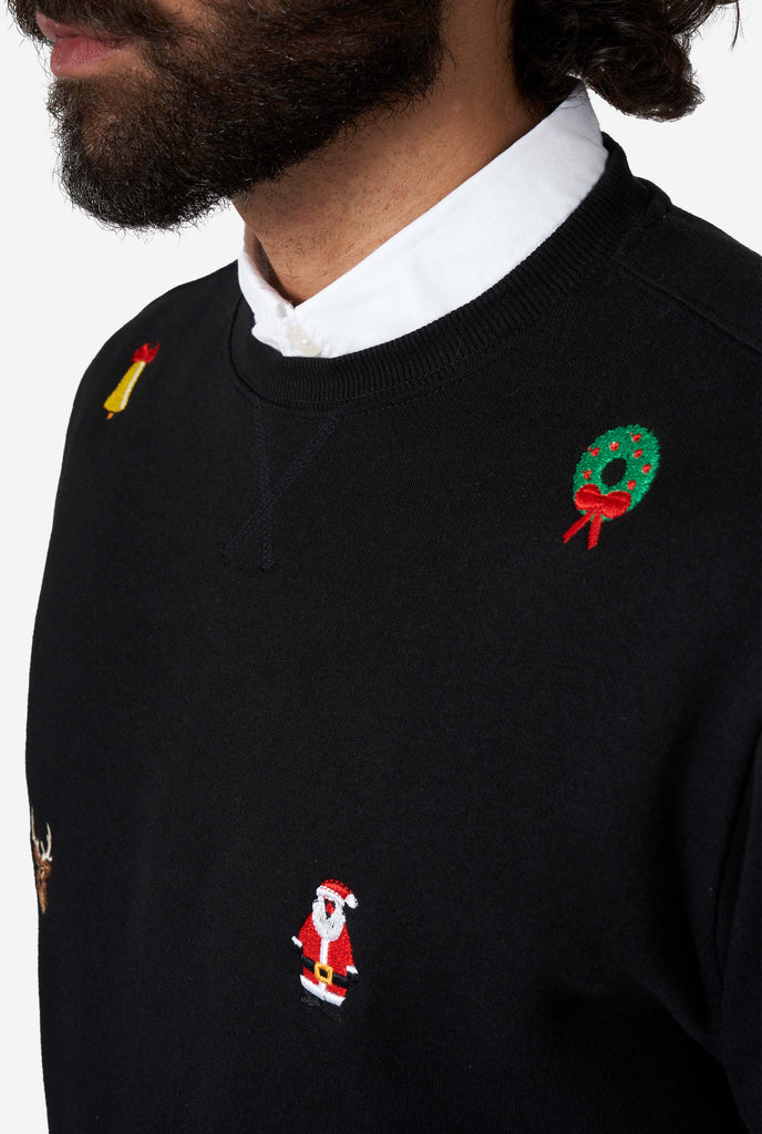 Man wearing black Christmas sweater with Christmas icons, close up