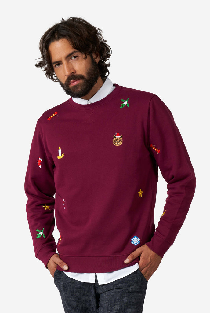 Man wearing burgundy red Christmas sweater with Christmas icons