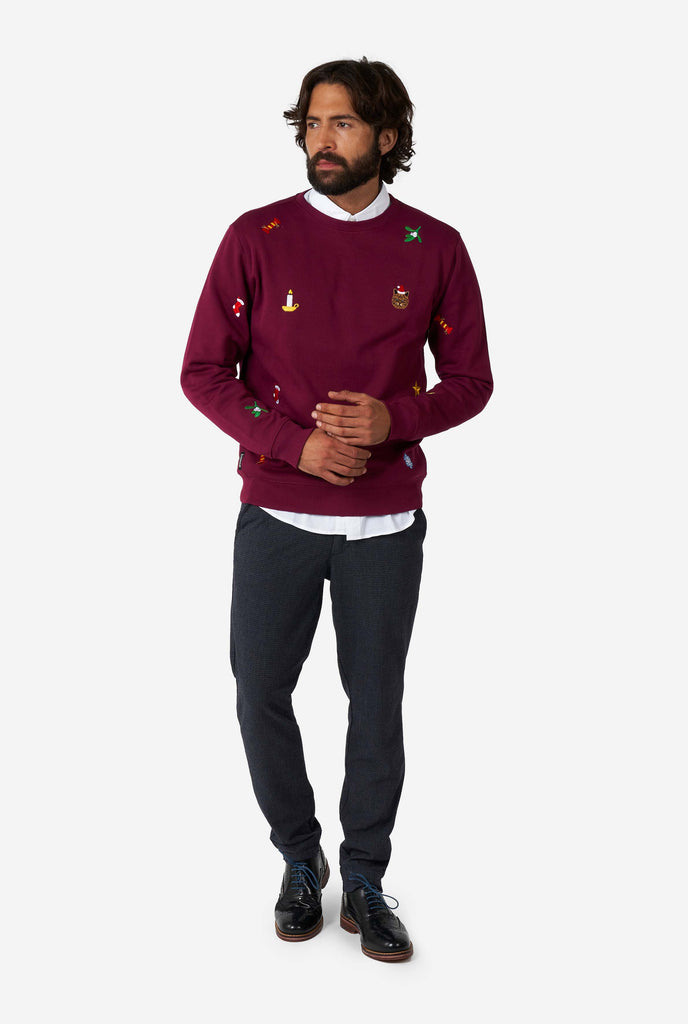 Man wearing burgundy red Christmas sweater with Christmas icons