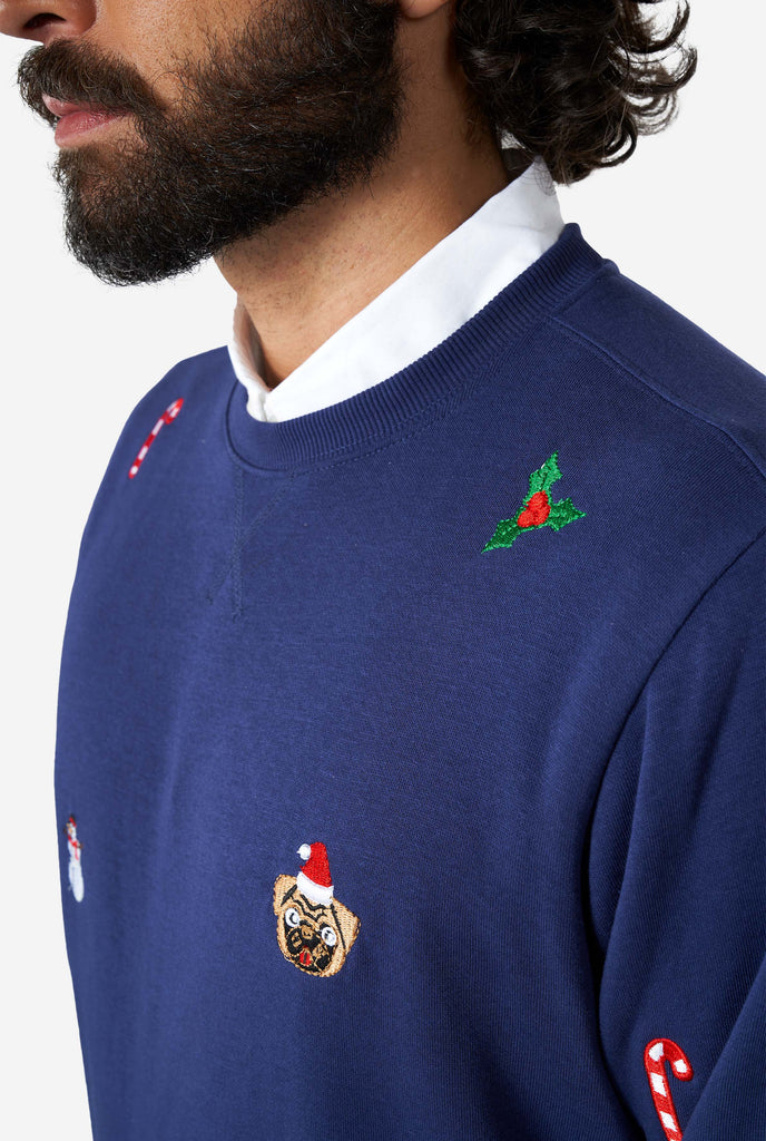 Man wearing blue Christmas sweater with Christmas icons, close up