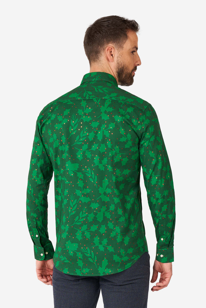 Man wearing green Christmas dress shirt with holly and mistletoe print, view from the back