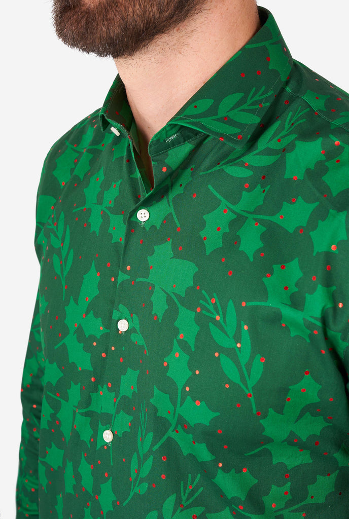 Man wearing green Christmas dress shirt with holly and mistletoe print, close up