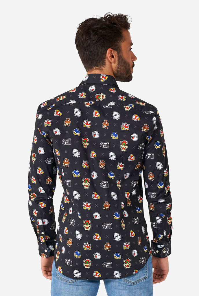 Man wearing black dress shirt with Super Mario bad guys icons, view from the back