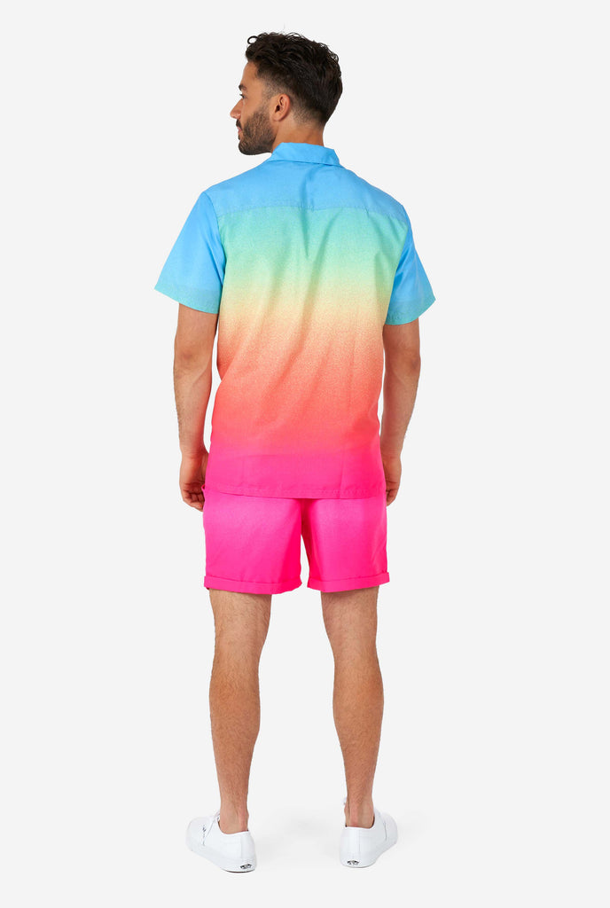 Man wearing colorful summer shorts and shirt, view from the back