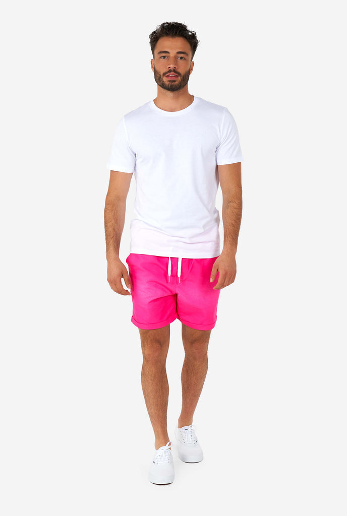 Man wearing colorful summer shorts and a white shirt