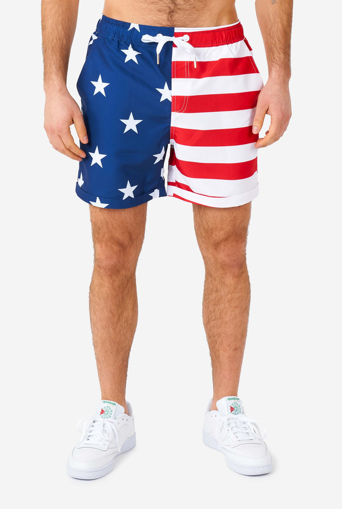 Man wearing summer outfit, consisting of shirt and shorts, with USA flag print, shorts close up