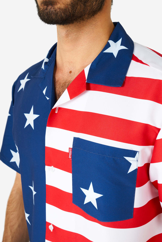 Man wearing summer outfit, consisting of shirt and shorts, with USA flag print, shirt close up