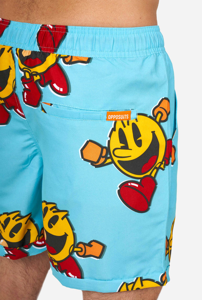 Man wearing blue summer shorts with Pac-Man print, close up