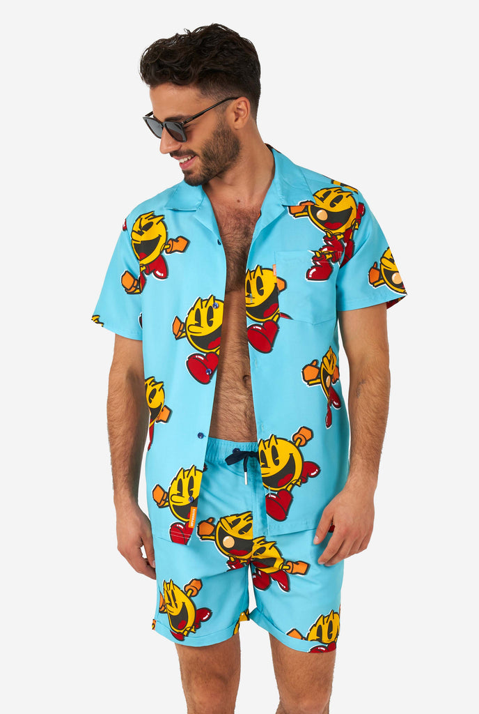 Man wearing blue summer shorts and shirt, with Pac-Man print