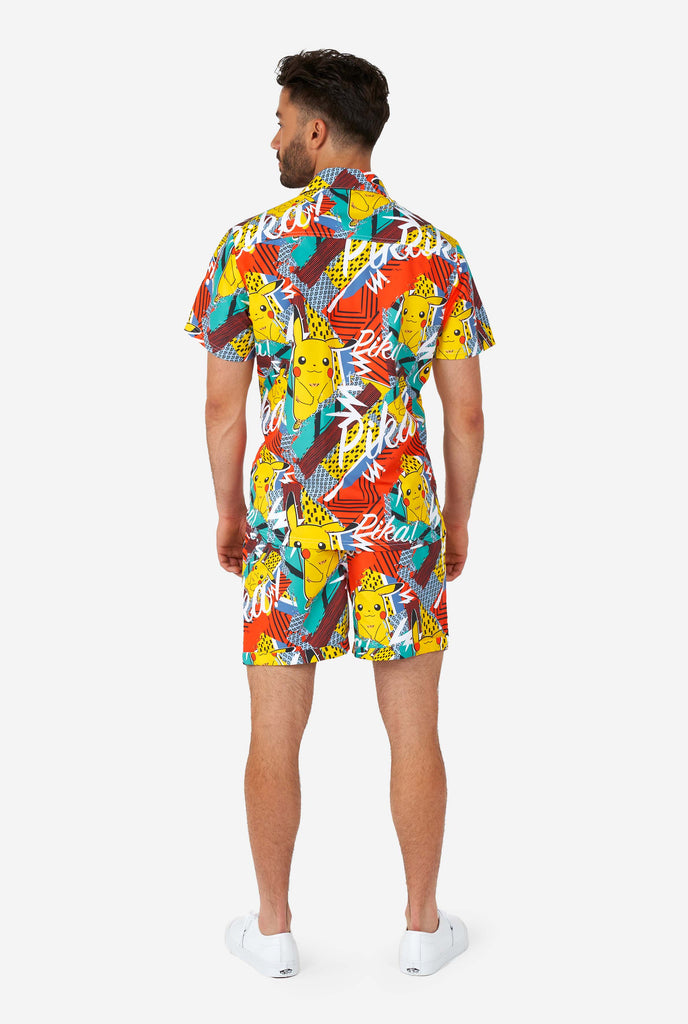 Man wearing colorful summer shorts and shirt with Pikachu Pokemon print, view from the back