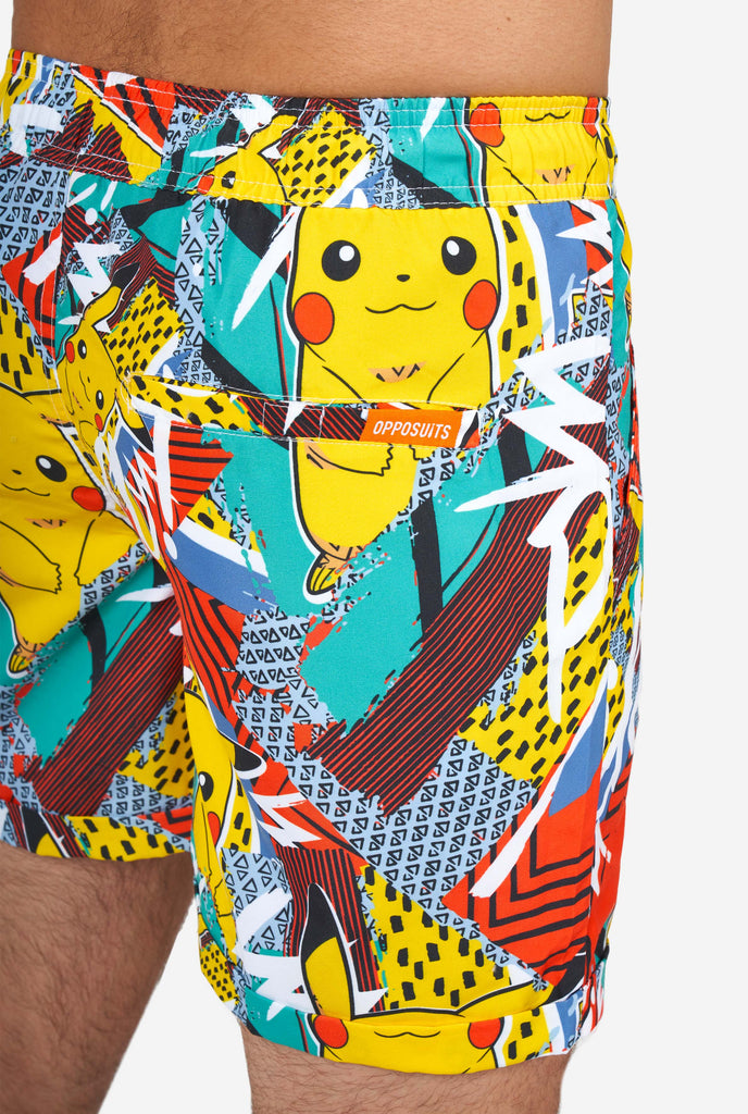 Man wearing colorful summer shorts with Pikachu Pokemon print, close-up from the back