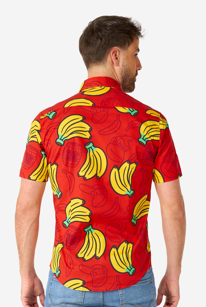 Man wearing red summer shirt with Donkey Kong print, view from the back