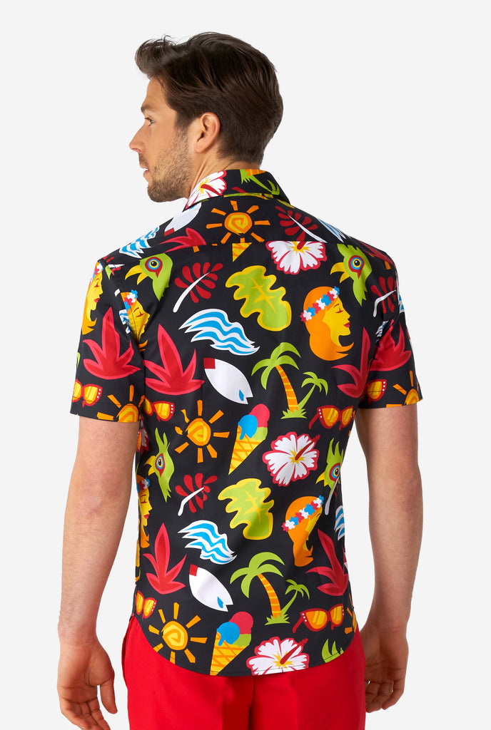 Man wearing black summer shirt with tropical icons and red short, view from the back