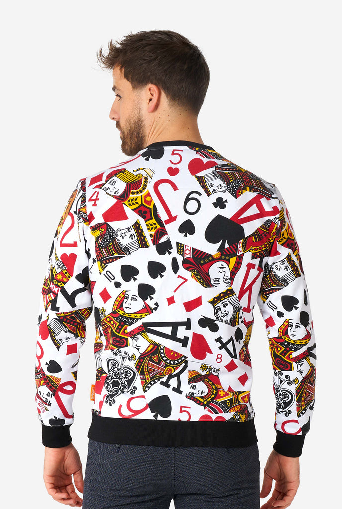 Man wearing white sweater with playing cards print, view from the back