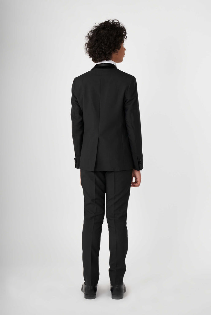 Teen wearing black tuxedo, view from the back