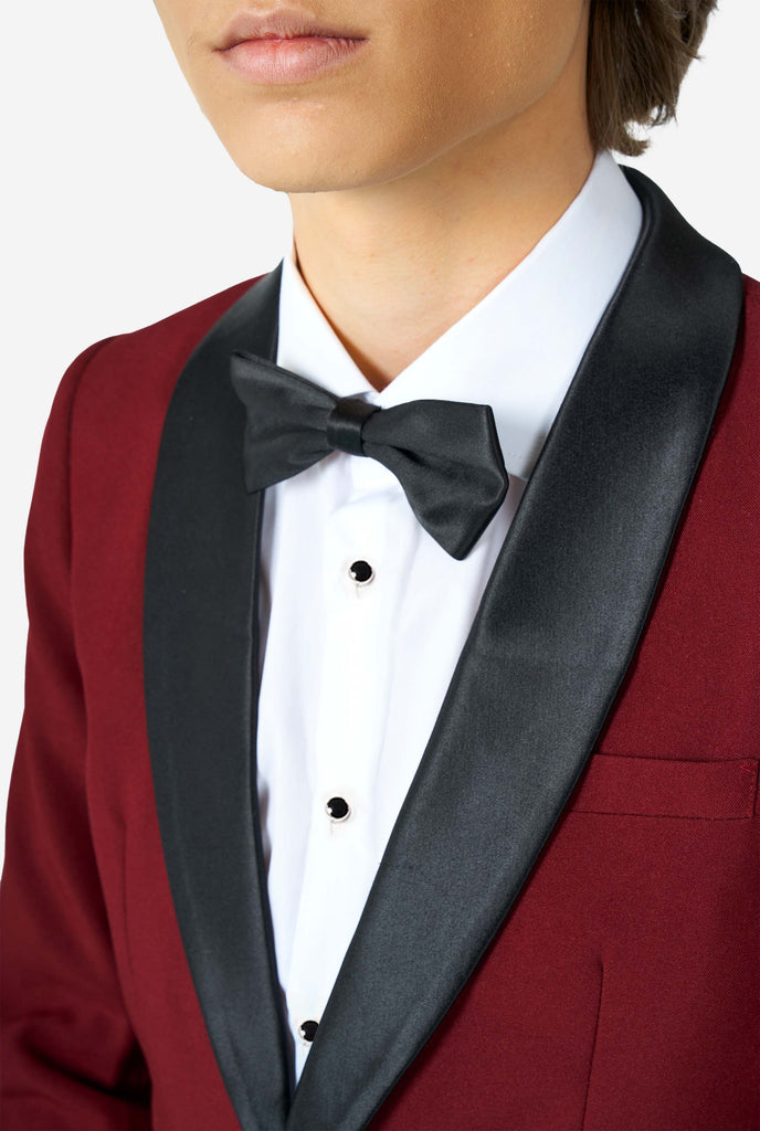 Teen wearing burgundy red and black tuxedo, close up