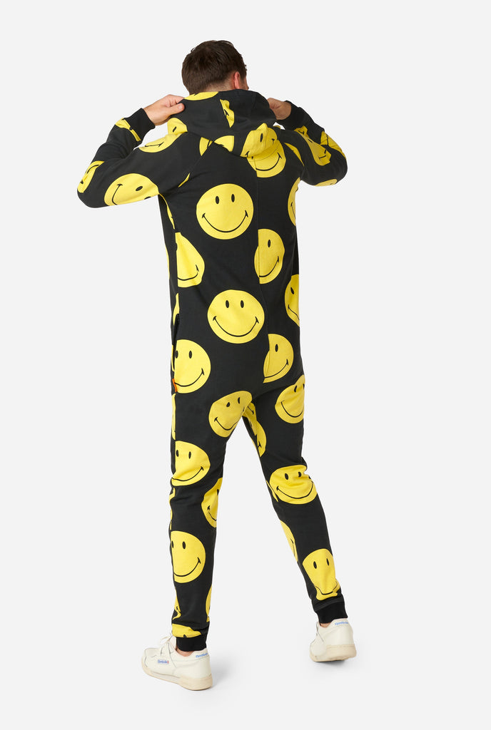 Man wearing black onesie with yellow smiley print, view from the back